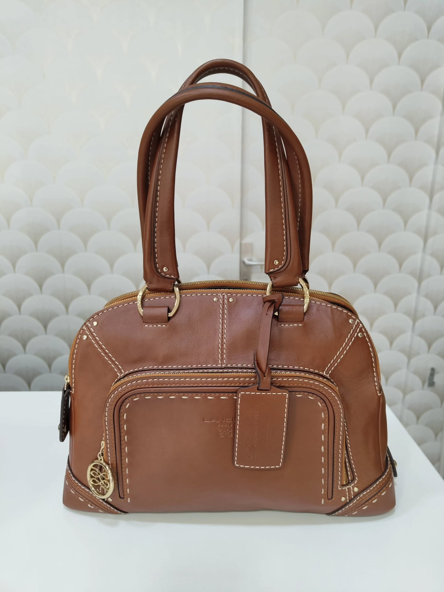 LANCEL — Modèle Mademoiselle Adjani en cuir cognac ✨
​Un incontournable de la maison Lancel ! Avec ses finitions surpiquées, ses détails dorés et son style bohème chic intemporel, c’est le sac parfait pour structurer une tenue au quotidien. 🤎

📩 Prix & Infos : Envoyez-nous un message privé (DM) pour réserver ou obtenir plus de détails !